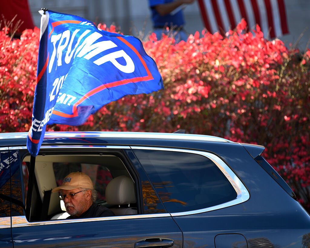 A supporter of President Donald Trump sits inside a car
